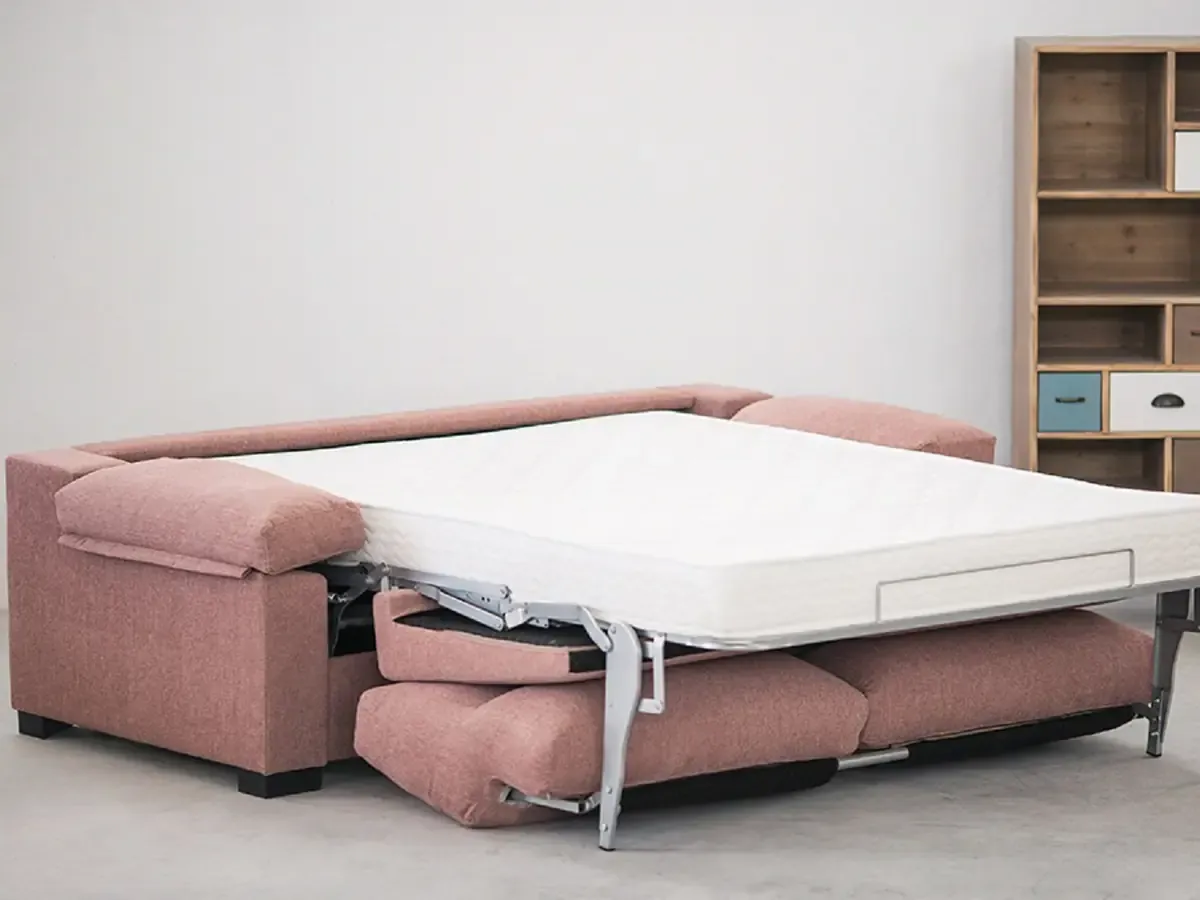 Sofá cama rosa abierto con el colchón a la vista