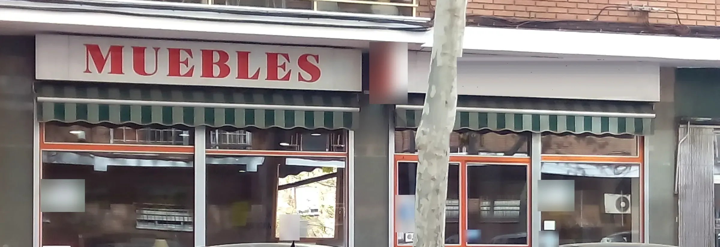 Fachada de la tienda: rótulo rojo, toldos verdes y escaparates