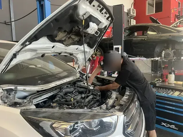 Mecánico trabajando en el motor de un coche